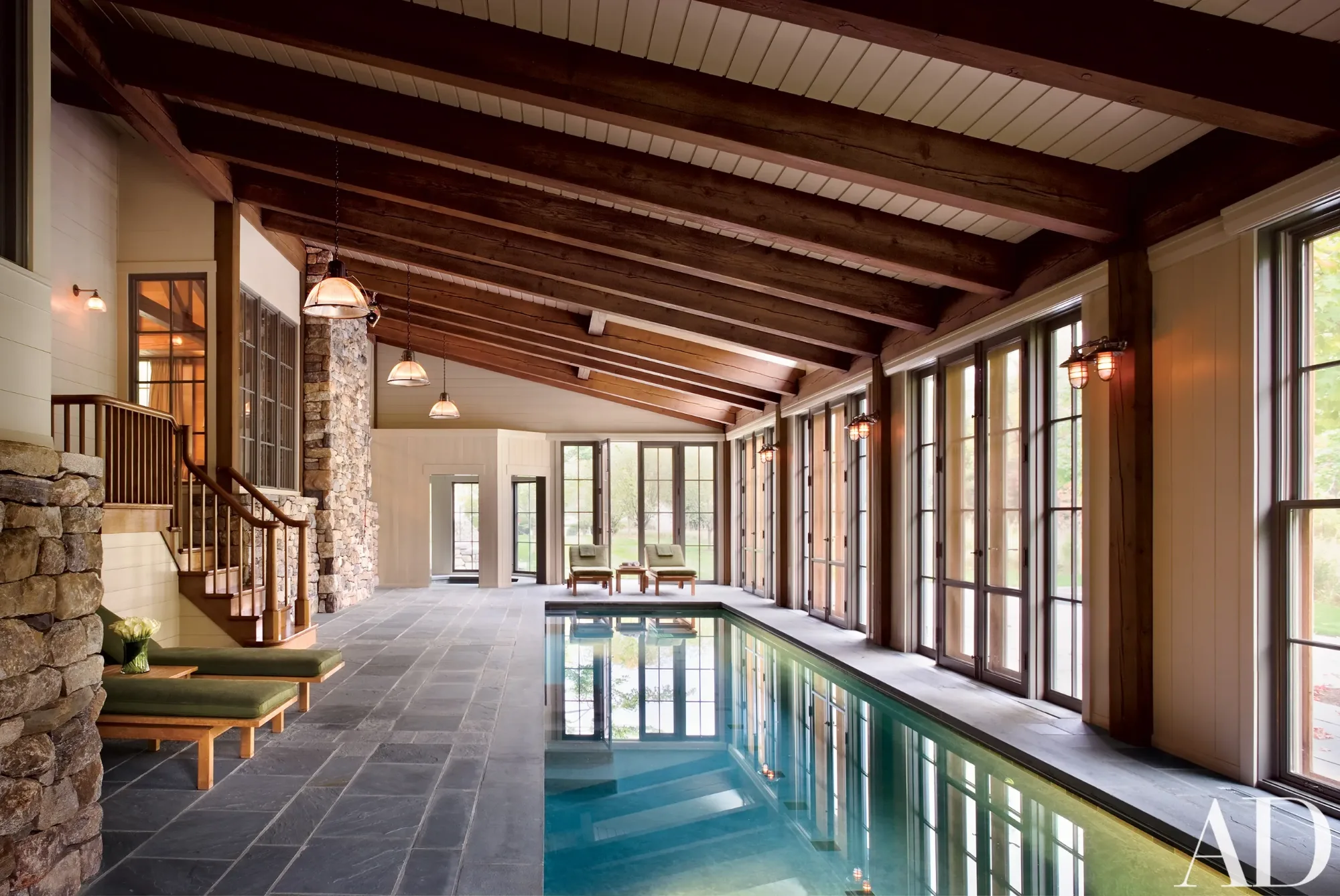 Exposed timber beams spanning a bright indoor pool room