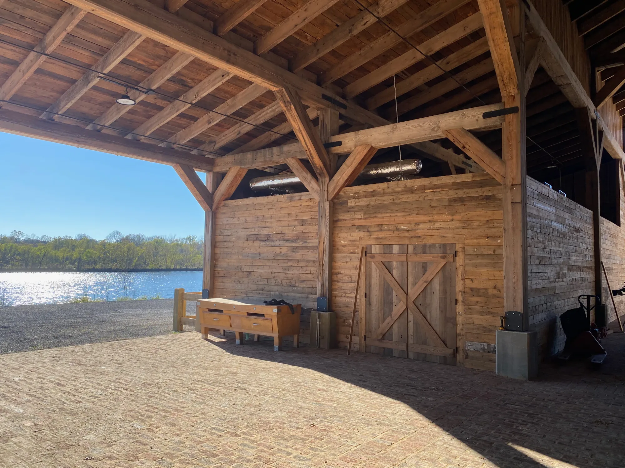 Exposed timber posts, beams and braces beneath a lakeside barn roof