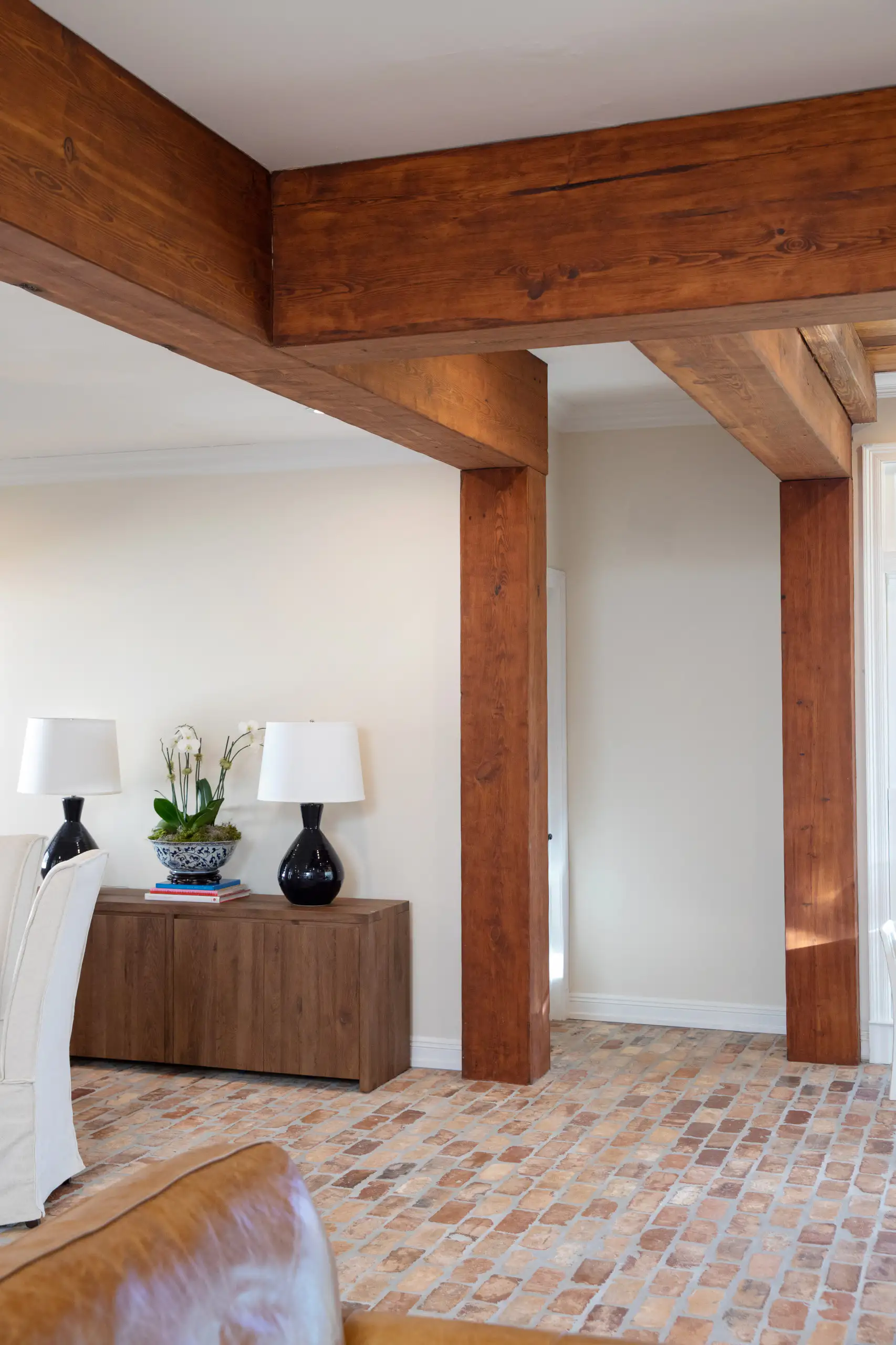Reclaimed beams and posts framing the opening between two rooms