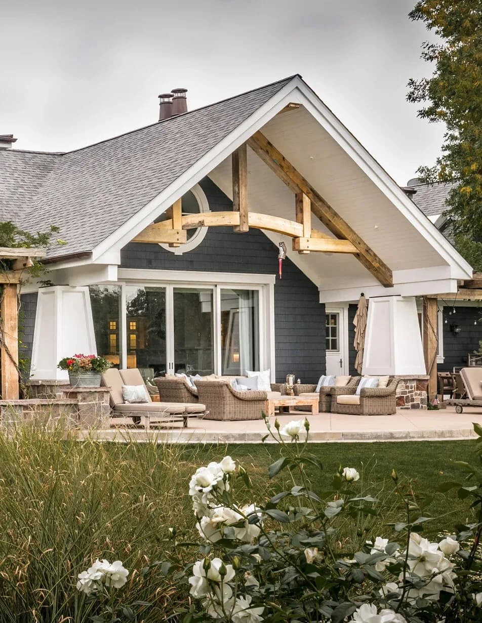 A shingled lake house with a timber porch